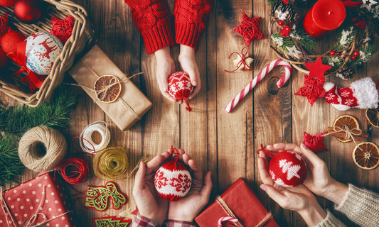 Hands holding eco-friendly baubles and wrapping presents for an Eco-friendly Christmas