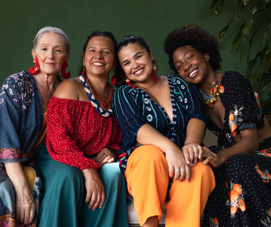 4 women sitting close together of different ethnic minorities