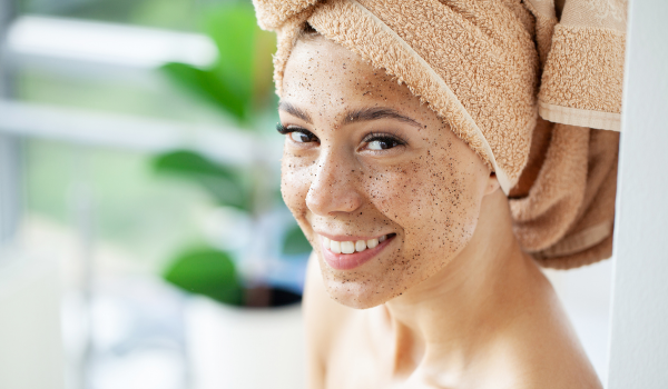 Smiling Lady With Face Scrub On And Hair Wrapped In Towel