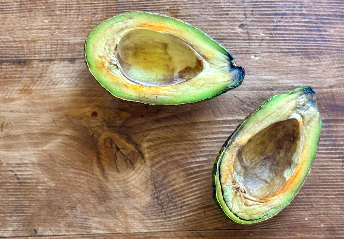 Halved avocado showing signs of spoilage and oxidation