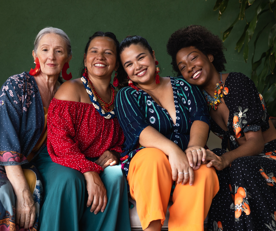 4 women sitting close together of different ethnic minorities 